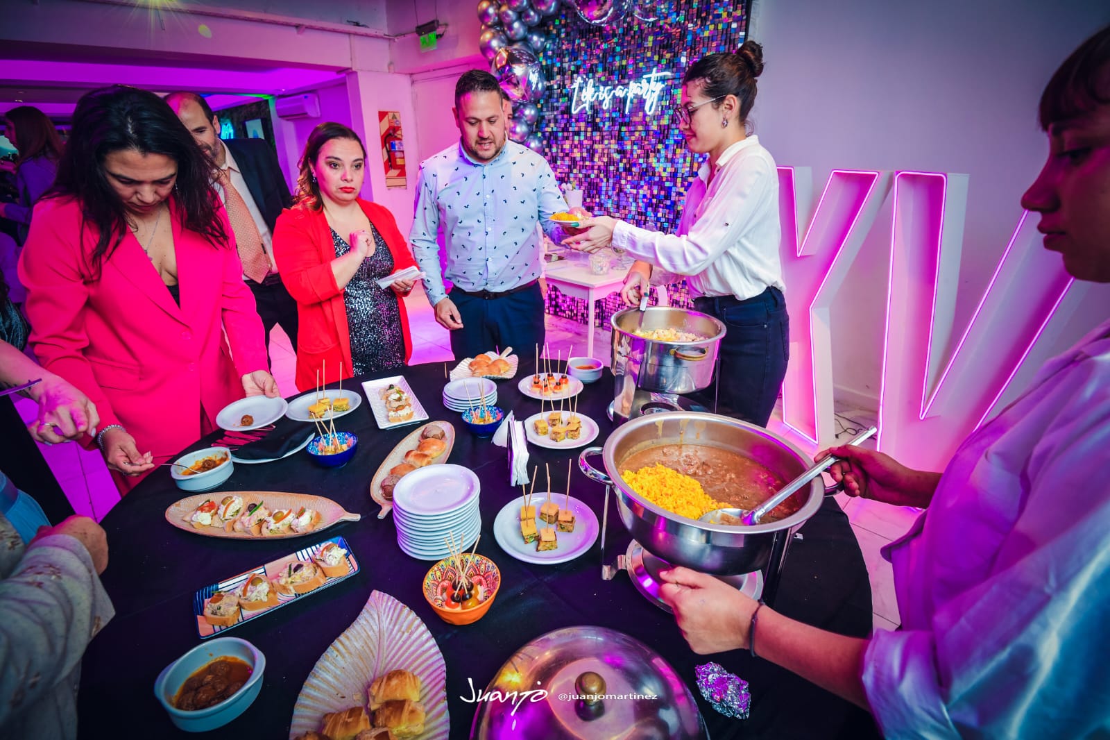 Isla de comida con invitados sirviéndose